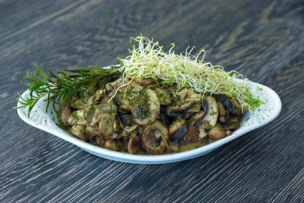 A dish of sauteed button mushrooms