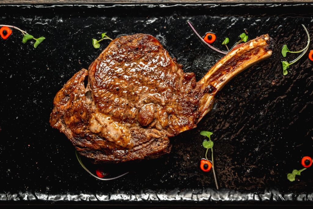 A bone-in USDA Prime cowboy steak on a slate board