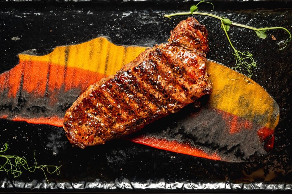 A grilled USDA Prime New York strip on a slate board