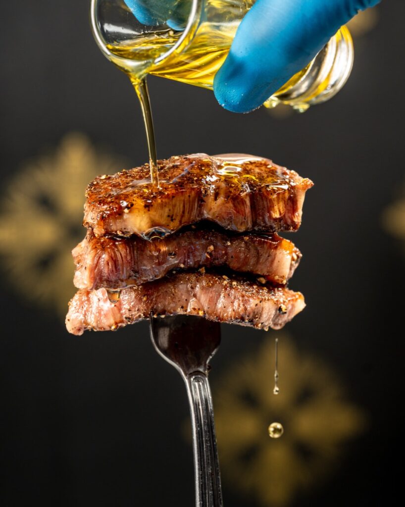 Warm oil poured over a stack of seared A5 wagyu slices